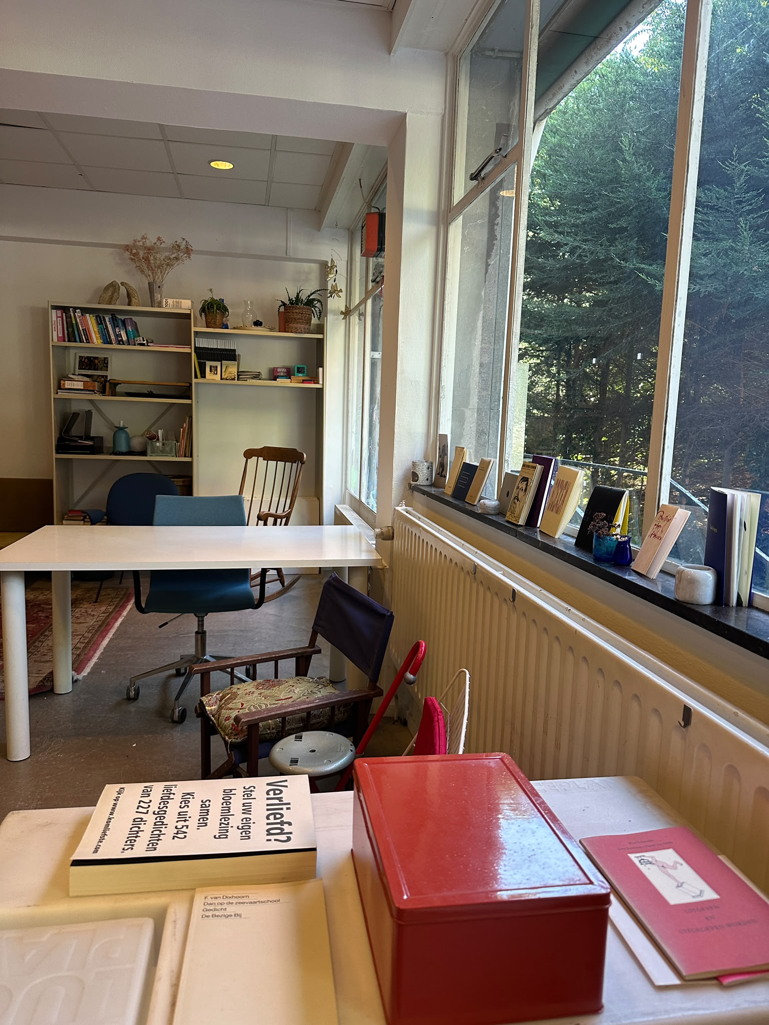 Atelier 0.001, de lichte dagbestedingsruimte met een tafel en zicht op de tuin